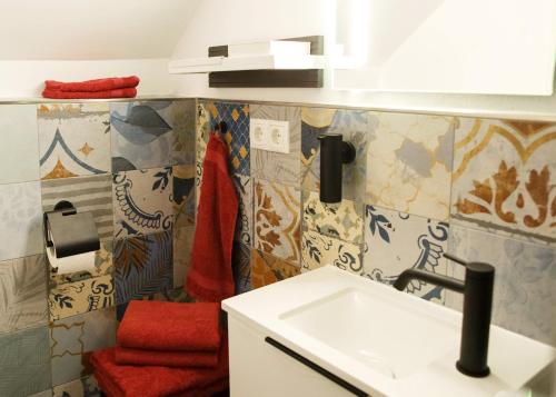 La salle de bains est pourvue d'un lavabo et d'une serviette rouge. dans l'établissement Apartment Basedow, à Basedow