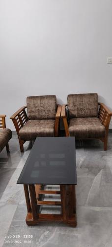 a living room with two chairs and a table at Oman house 2.O in Ernakulam