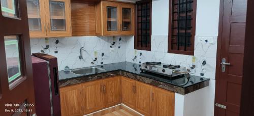 a kitchen with a sink and a stove in it at Oman house 2.O in Ernakulam
