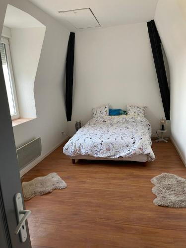 - une chambre avec un lit et deux tapis au sol dans l'établissement Château Japy Appartement La Chappelle, à Dasle