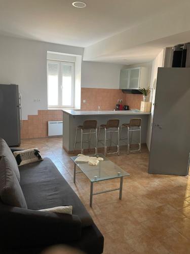 un salon et une cuisine avec un canapé et une table dans l'établissement Château Japy Appartement La Chappelle, à Dasle