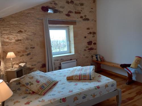 Schlafzimmer mit einem Bett und einem Fenster in der Unterkunft Gîtes Lalaurie in Sauveterre-la-Lémance
