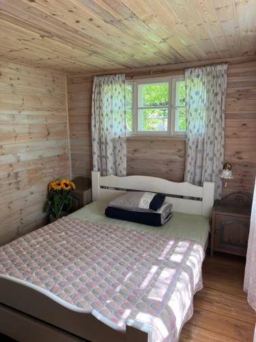 a bedroom with a bed in a wooden cabin at Aadniel's Holiday Village in Aula