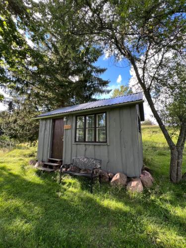 a small shed with a bench in the grass at Aadniel's Holiday Village in Aula