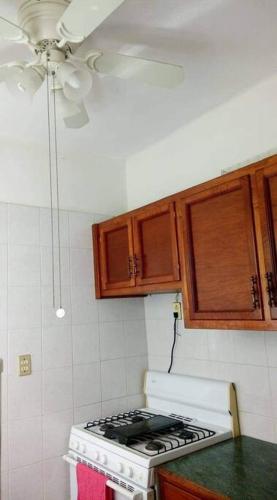 a kitchen with a stove and wooden cabinets at Amplio y acogedor -2D 1B in Tuxpan de Rodríguez Cano