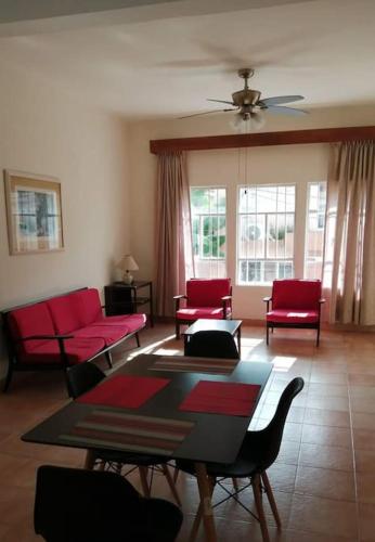 ein Wohnzimmer mit roten Stühlen und einem Tisch in der Unterkunft Amplio y acogedor -2D 1B in Tuxpan de Rodríguez Cano