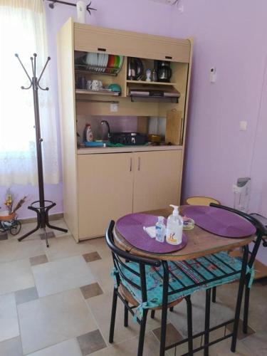 a table and chairs in a room with a kitchen at Η ΑΝΕΣΗ in Agia Anna Naxos