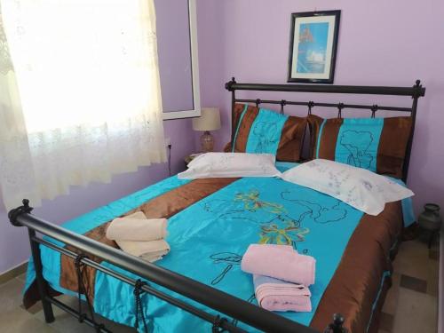 a bedroom with a blue bed with towels on it at Η ΑΝΕΣΗ in Agia Anna Naxos
