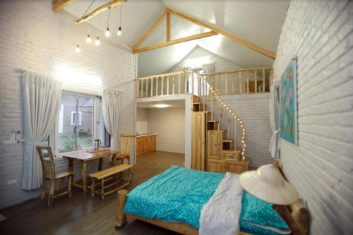 um quarto com uma cama, uma mesa e uma escada em Fefe garden em Ba Vì
