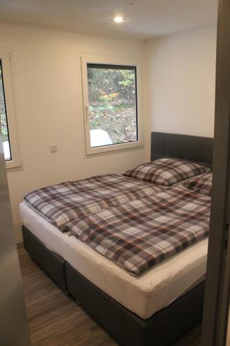 a bed in a room with a window at Ferienhaus Refugium in Sessenbach