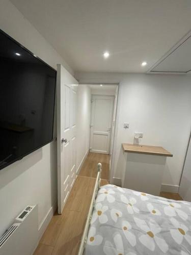 um quarto com uma cama e uma televisão de ecrã plano em 1 bedroom guest suite near city centre. em Gloucester