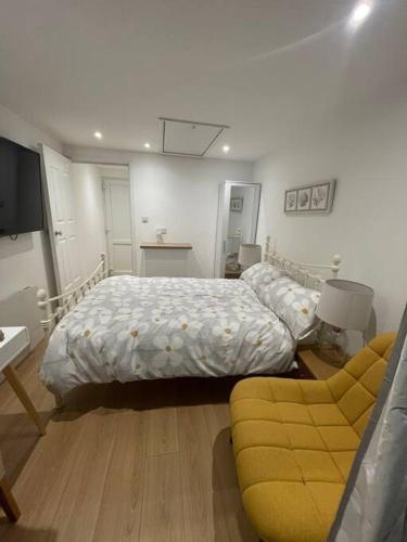 a bedroom with two beds and a couch in it at 1 bedroom guest suite near city centre. in Gloucester