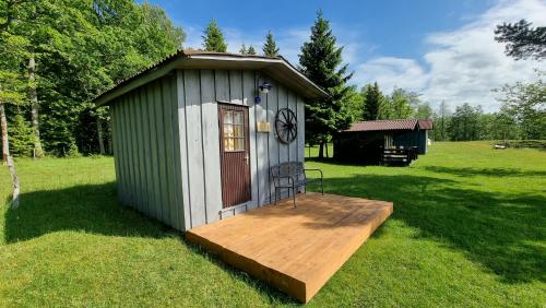 a small shed with a wooden deck in a field at Aadniel's Holiday Village in Aula