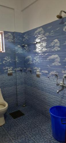 a bathroom with a shower with birds on the wall at THEKKADY HOMES in Thekkady