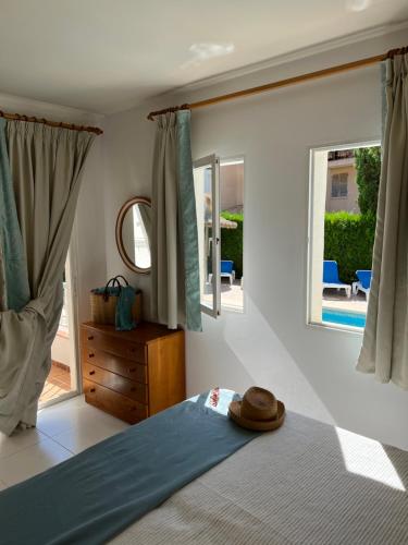 een slaapkamer met een bed met een hoed erop bij Villa Alexia - APARTMENT ISLA - Sunny One Bedroom Apt - Balcony-Terrace in Port de Pollença