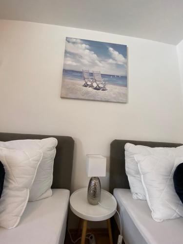 a bedroom with two beds and a table with a lamp at Apartman Hana u blizini Automotodroma Grobnik i Kostrenski plaža in Kostrena