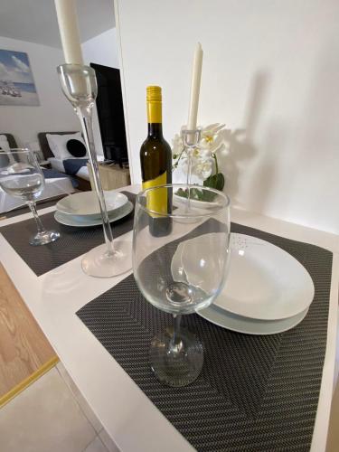 a table with two glasses and a bottle of wine at Apartman Hana u blizini Automotodroma Grobnik i Kostrenski plaža in Kostrena