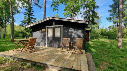 a cabin with a table and chairs on a wooden deck at Aadniel's Holiday Village in Aula