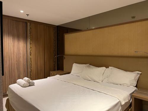 een slaapkamer met een groot bed met witte lakens bij Brisas do Lago in Brasilia