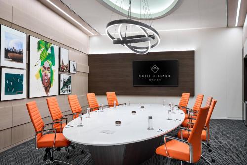 a conference room with a large white table and orange chairs at Hotel Chicago Downtown, Autograph Collection in Chicago