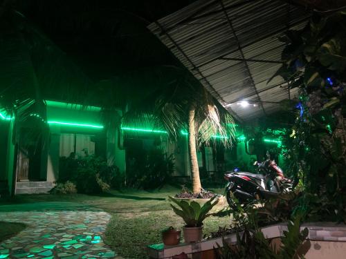 a motorcycle parked in front of a building with green lights at AMK traveller's hub in Maite