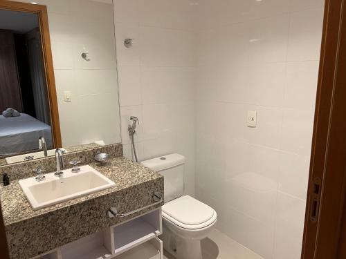 a bathroom with a toilet and a sink and a mirror at Brisas do Lago in Brasilia