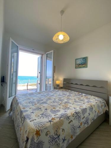 a bedroom with a bed with a view of the ocean at La Porta sul Lungomare in Castelsardo