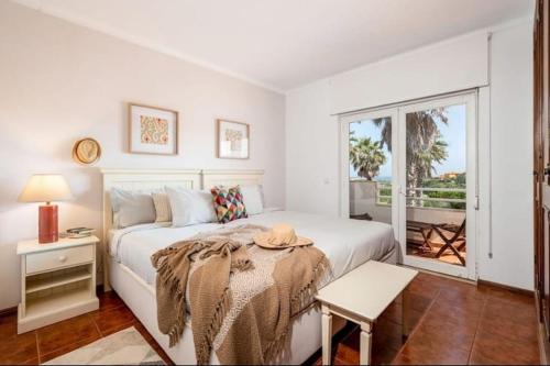 - une chambre blanche avec un lit et une fenêtre dans l'établissement Pool/Golf/Ocean resort home in Amoreira, à Amoreira