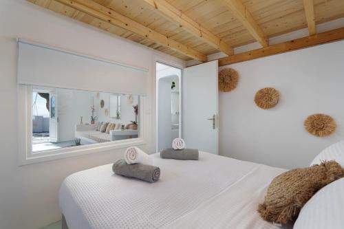 a bedroom with a white bed and a large window at Red beach Harmony Suites Stone house in Akrotiri