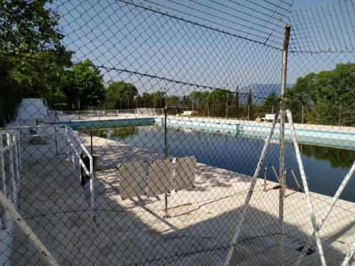 a fence in front of a swimming pool at Casa con jardín, 1 habitación, barbacoa in Collado Mediano