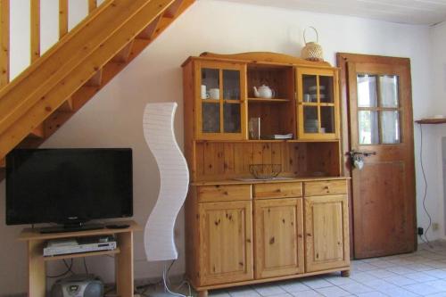 - un salon avec une télévision et une armoire en bois dans l'établissement Petite maison entre mer et campagne, aux Pieux