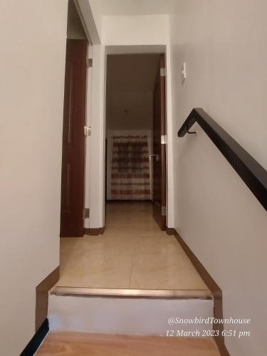 a hallway of a house with stairs and a stair case at Snowbird Townhouse Azumi in Dumaguete