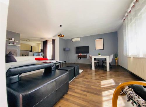 een woonkamer met een bank, een bed en een tafel bij Apartment Zvečaj in Ðakovo