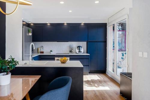 une cuisine avec des placards bleus et une table en bois dans l'établissement T3 Le Designer 4è-Terrasse-climatisation & Netflix, à Marseille