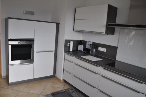a kitchen with white appliances and a black counter top at Schnurs Ferienwohnung in Römerberg