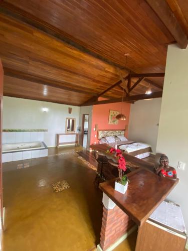 Cette chambre dispose de deux lits et d'un plafond en bois. dans l'établissement Chalés Lavras de Minas - Canadá, à Lavras Novas