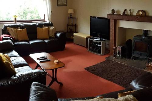 a living room with leather furniture and a fireplace at Halsteads: peaceful location, stunning views in Soutergate