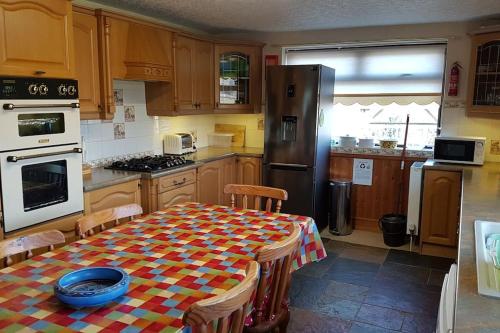 a kitchen with a table with a checkered table cloth at Halsteads: peaceful location, stunning views in Soutergate