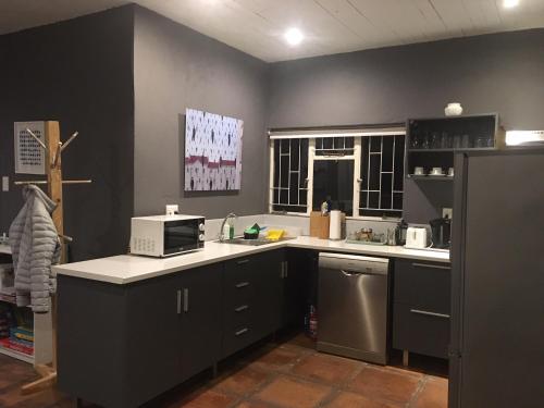 a kitchen with a sink and a microwave at Bramber Cottage Hogsback, Living With Joy! in Hogsback