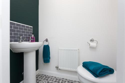 ein weißes Badezimmer mit einem Waschbecken, einem WC und einem Waschbecken in der Unterkunft Main Street Town House in Leyland