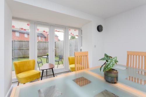 a living room with a glass table and chairs at Main Street Town House in Leyland
