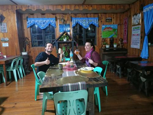 a man and woman sitting at a table with drinks at Las vegas lodge and restaurant in Banaue
