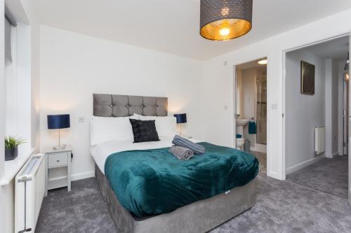 a bedroom with a large bed with a green blanket at Main Street Town House in Leyland