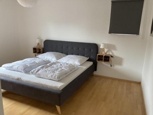 a bed in a bedroom with two lamps on the wall at Appartment Griesheim in Griesheim