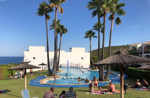 a group of people in a swimming pool with palm trees at La casa de Leones in Peniscola