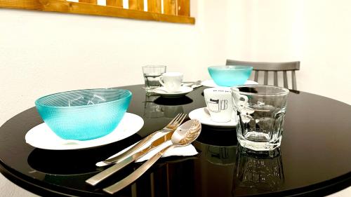 a black table with plates and glasses on it at Urban Luxus Studio II in Heraklio Town
