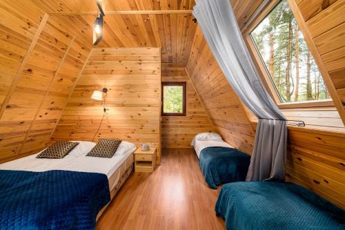 a bedroom with two beds in a log cabin at Krasne Domki in Krasnobród