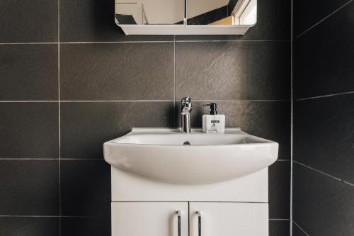 a bathroom with a white sink and a mirror at Top quality beach front apartment sleep up to 7 guests in Bournemouth