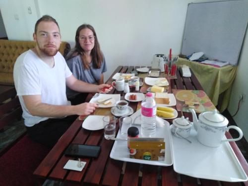 a man and a woman sitting at a table with food at Y&Y Residence in Kandy