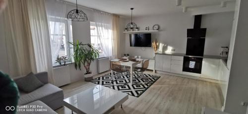 a living room with a couch and a table and a kitchen at Elen & K in Polkowice